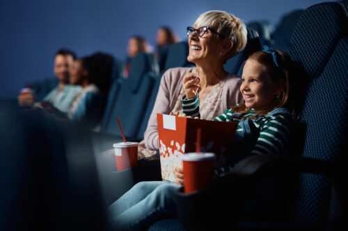 People watching a show at the cinema with popcorn.