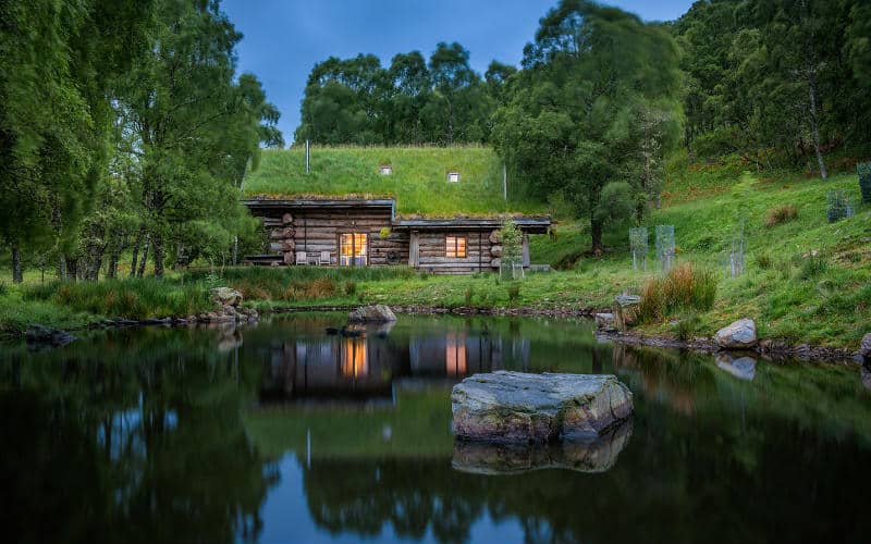 Pond overlooking Loxia log cabin at dusk