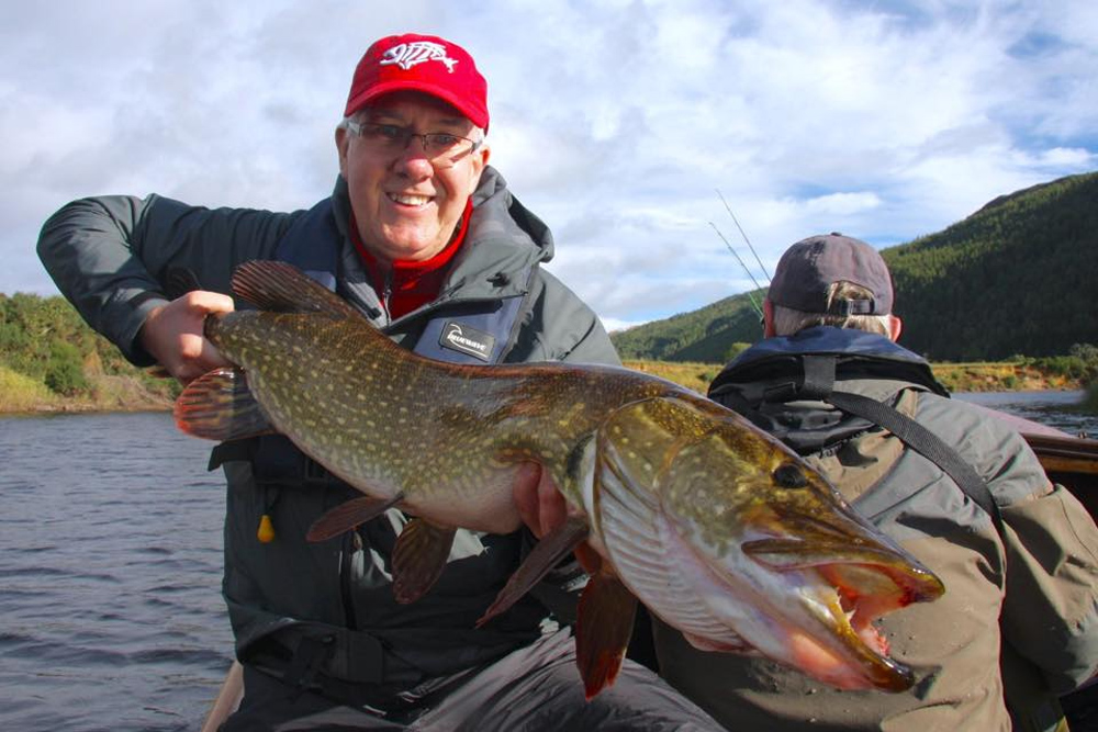 Man holding a fish on holiday fishing in Scotland