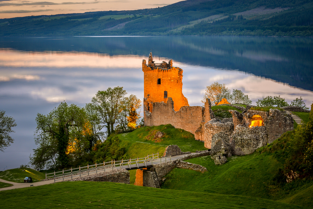 Urquhart castle lit up in the evening on loch ness