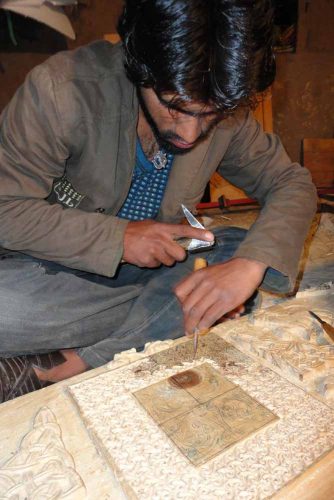 Craftsman carving Eagle Brae panels by hand