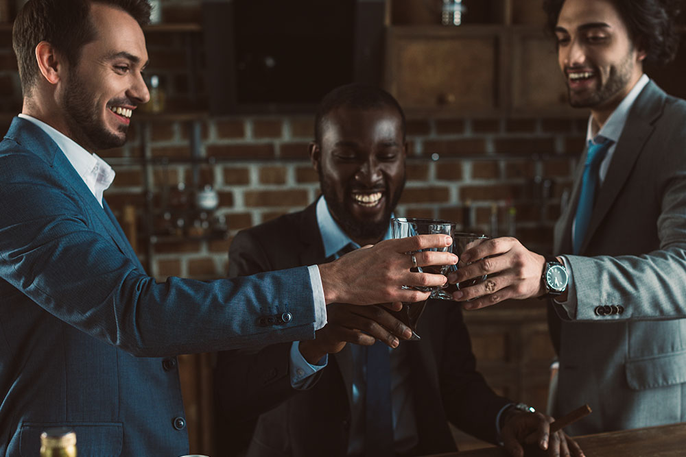 Three men share a drink together.