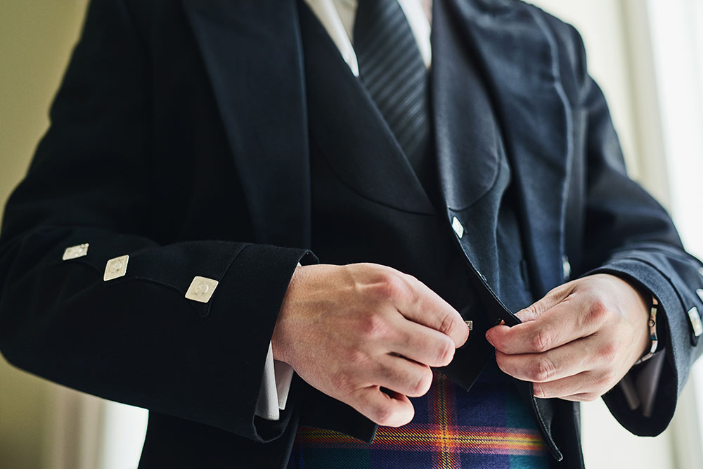 A man dressed in Scottish clothing including a kilt with tartan.