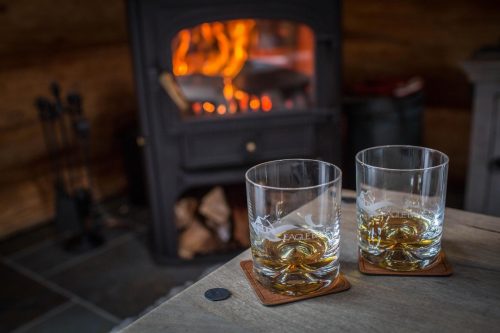 Whisky glasses in front of a log burner at Eagle Brae